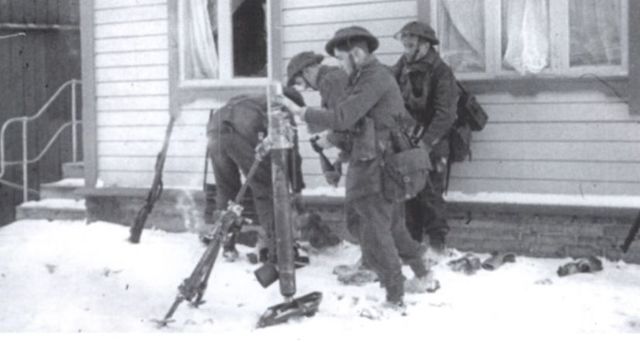 Mortero en Vaagso abriendo fuego sobre las posiciones alemanas. Se ocultan del fuego de los francotiradores alemanes tras los edificios