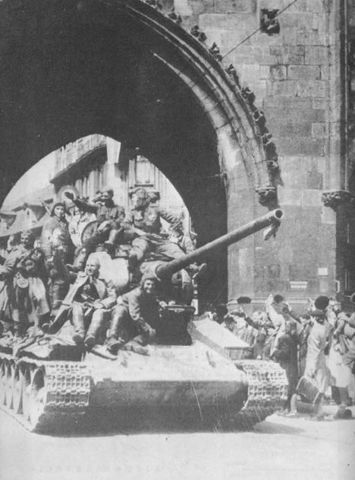 Soldados soviéticos encaramados a un T-34 85 son recibidos con alegría por la población de Praga. Mayo de 1945